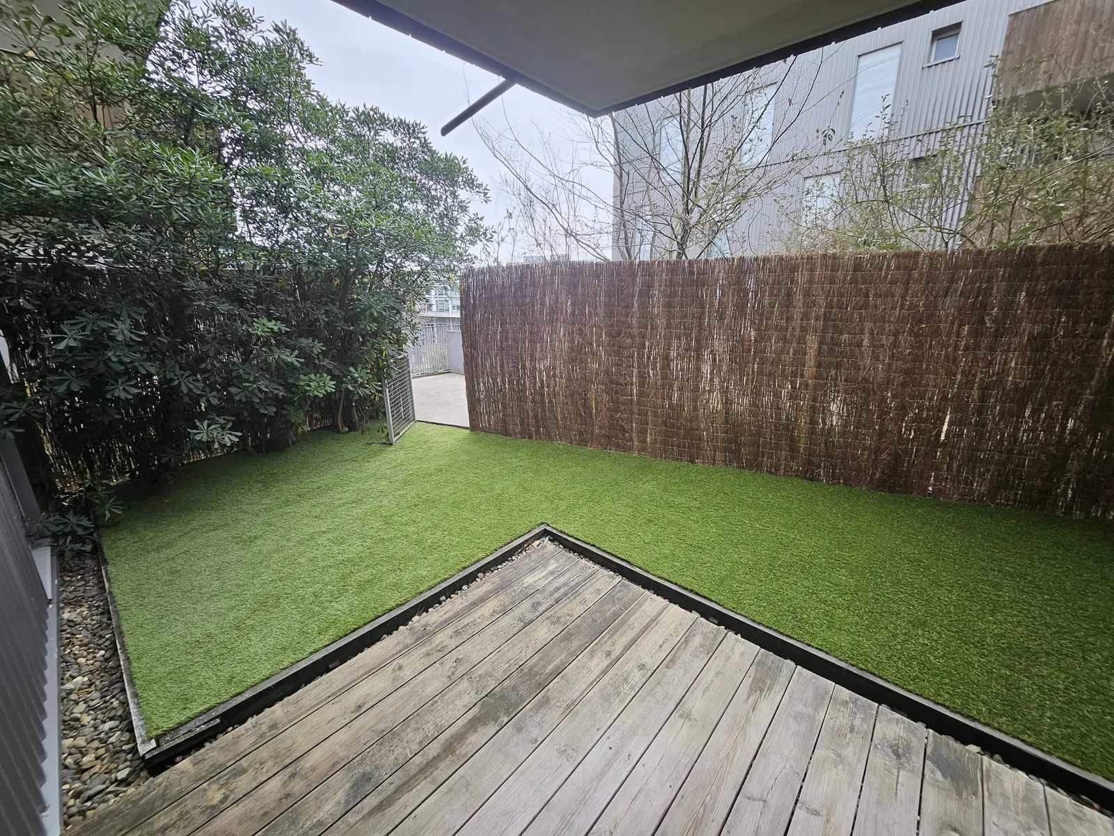 Cour entretenue avec gazon synthétique et brise-vue, extérieur soigné sur le Bassin d'Arcachon